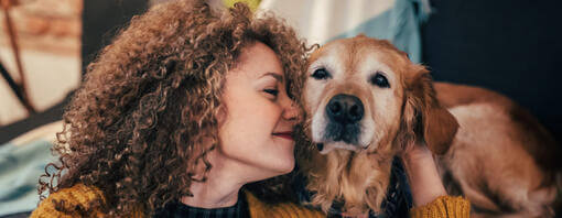 Woman cuddling old Golden Retriever